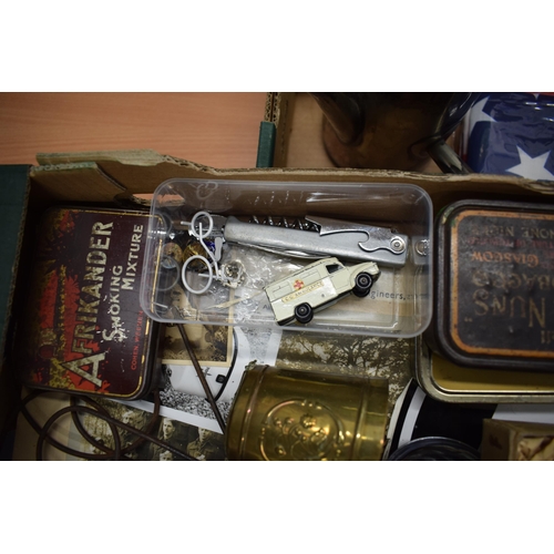 164 - A mixed collection of items to include vintage advertising tins, Puch and GB automobilia stickers, a... 