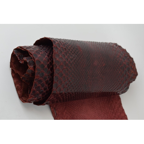 203 - A snake skin dyed maroon suitable for crafting or leatherwork. Section has been cut out. Length 267c... 