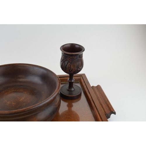 210 - A wooden butlers tray with glass liner, a turned wooden fruit bowl with a near pair of carved goblet... 