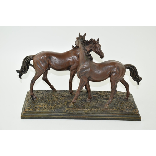 283 - A bronzed figure of two horses, a male and a female in resin. Height 25cm, width 34cm.