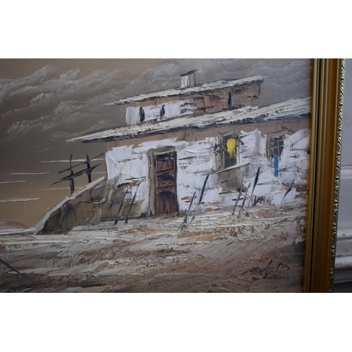 287 - Oil on Canvas, Fishing boat with houses on the shoreline in gilt frame. 29cm x 59cm.