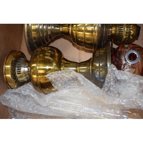 302 - A trio of brass oil lamps complete with shades. (3)