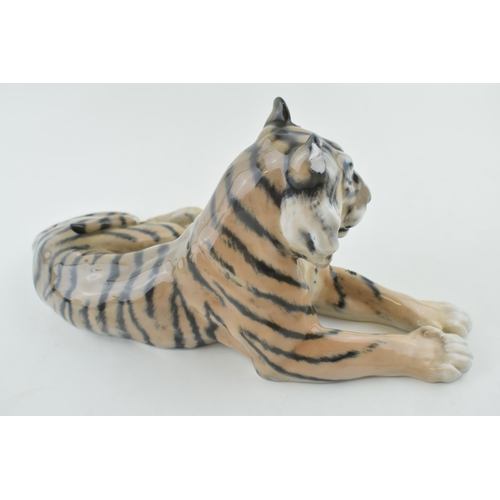 106 - Royal Copenhagen figure of a recumbent tiger, 31cm wide, chipped ear.