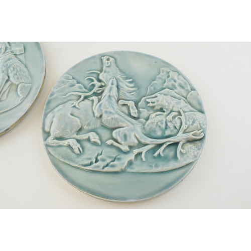 144 - Early to mid 20th century glazed roundel plaques, embossed decoration, one with a dog hunting stag s... 