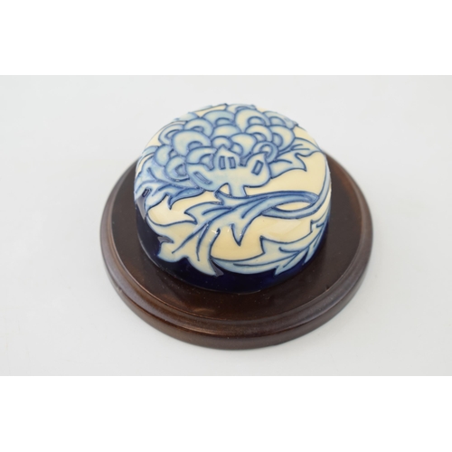 92 - Moorcroft blue floral paperweight mounted onto wooden stand.