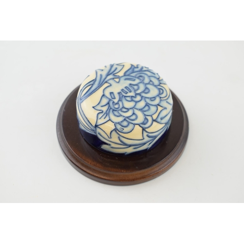 92 - Moorcroft blue floral paperweight mounted onto wooden stand.