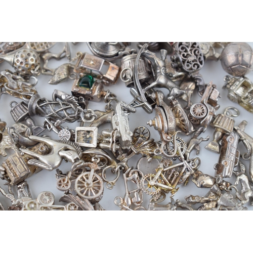 552 - A large collection of silver / silver coloured metal charms to include sporting items, birds, animal... 