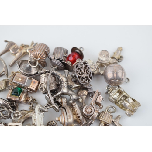 552 - A large collection of silver / silver coloured metal charms to include sporting items, birds, animal... 