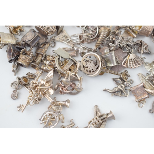 553 - A large collection of silver / silver coloured metal charms to include musical instruments, love hea... 