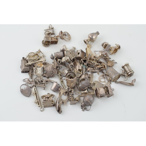 555 - A collection of silver charms to include a tankard, a fish, and many others, 165.4g.