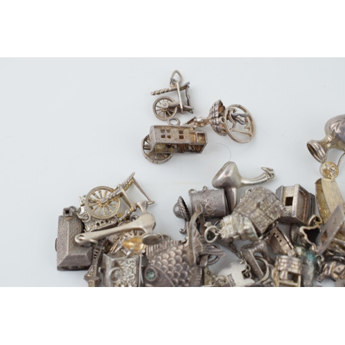 555 - A collection of silver charms to include a tankard, a fish, and many others, 165.4g.