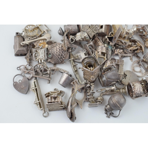 555 - A collection of silver charms to include a tankard, a fish, and many others, 165.4g.