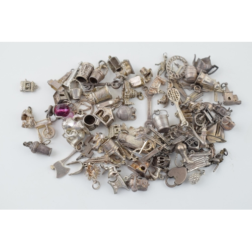 556 - A collection of silver charms to include kettles, cars, buildings and others, 168.5g.