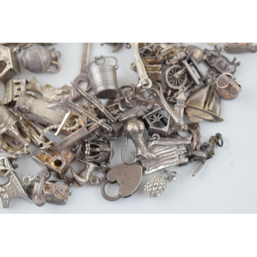 556 - A collection of silver charms to include kettles, cars, buildings and others, 168.5g.