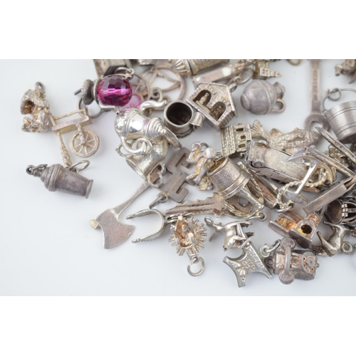 556 - A collection of silver charms to include kettles, cars, buildings and others, 168.5g.