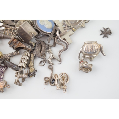 557 - A large collection of silver charms to include animals, tankards and others, 168g.