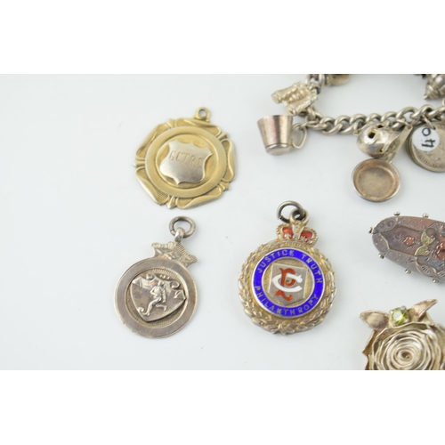 558 - Silver to include a charm bracelet, with four silver fobs and three brooches, 117.8g.