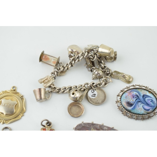 558 - Silver to include a charm bracelet, with four silver fobs and three brooches, 117.8g.