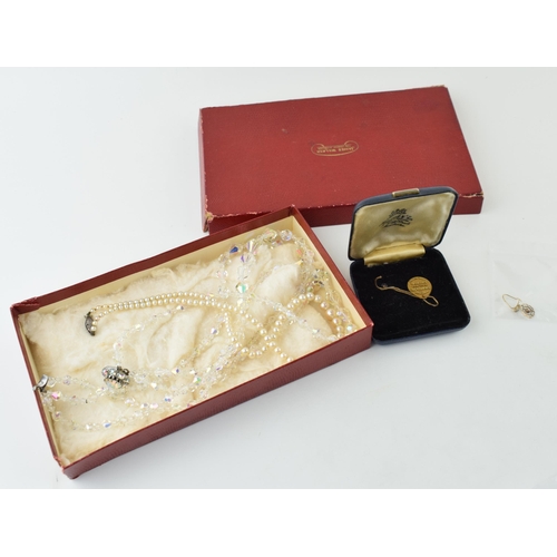 566 - A collection of vintage jewellery items to include a set of pearls a boxed Swarovski jewellery simiu... 