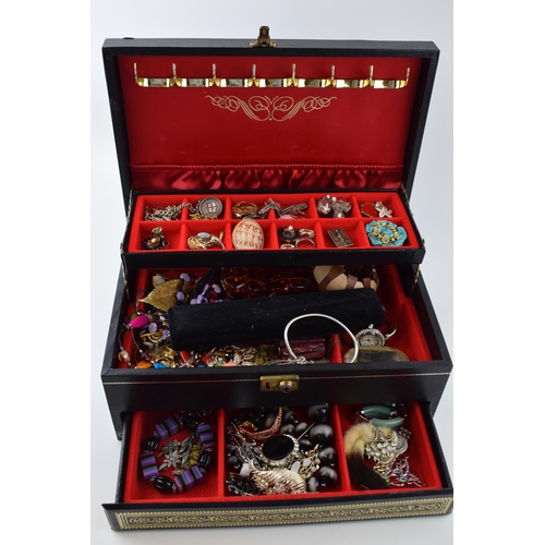 568 - A jewellery box of costume jewellery to include a metal albert watch chain with a silver fob, a Jady... 