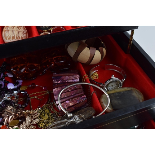 568 - A jewellery box of costume jewellery to include a metal albert watch chain with a silver fob, a Jady... 