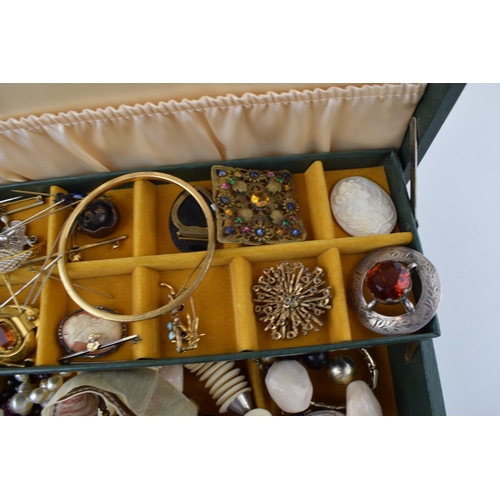 569 - A jewellery box with costume jewellery to include a silver topped glass jar, hat pins, a bronzed sma... 