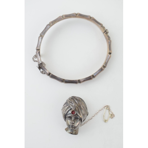 571 - A silver brooch in the form of a Turkish Boy's head, stone set, with a silver bangle, 30.6g (2).