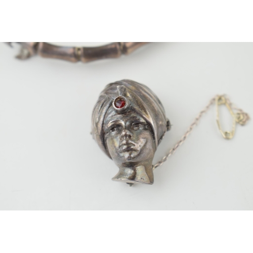 571 - A silver brooch in the form of a Turkish Boy's head, stone set, with a silver bangle, 30.6g (2).