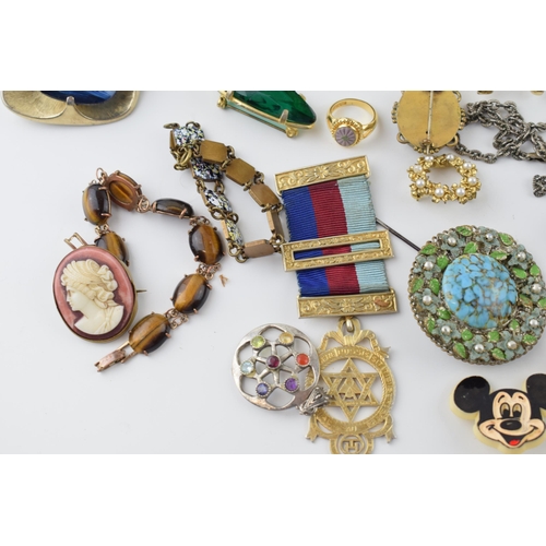 596 - A collection of costume jewellery to include mainly brooches of Victorian and later pieces, tigers e... 