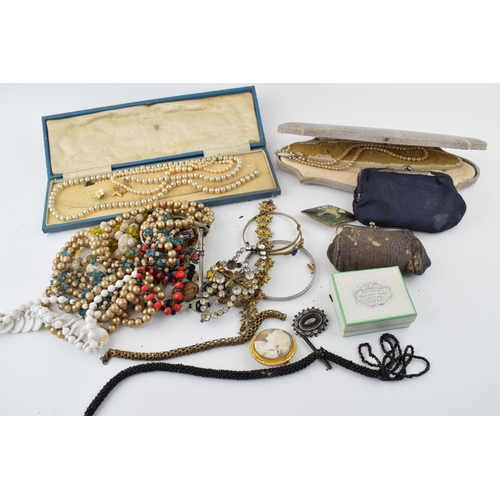 604 - Costume jewellery to include an albert chain, a cameo brooch, a silver brooch, purses with coins, od... 