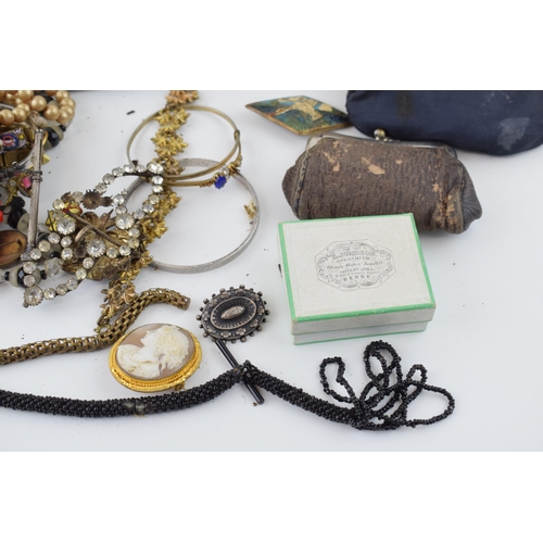 604 - Costume jewellery to include an albert chain, a cameo brooch, a silver brooch, purses with coins, od... 