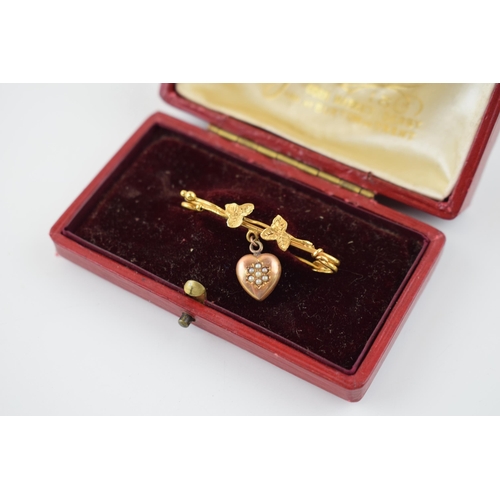 623 - 9ct gold brooch with suspended rose gold heart, floral design, 2.1g, in original case.