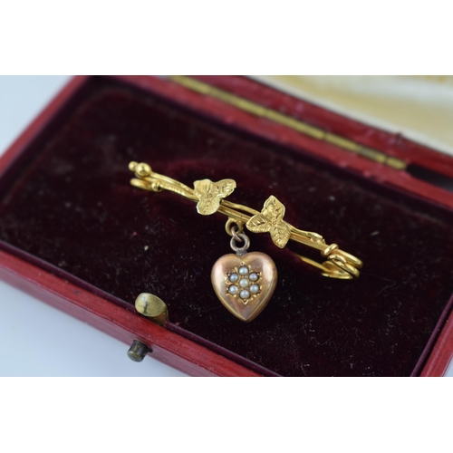 623 - 9ct gold brooch with suspended rose gold heart, floral design, 2.1g, in original case.