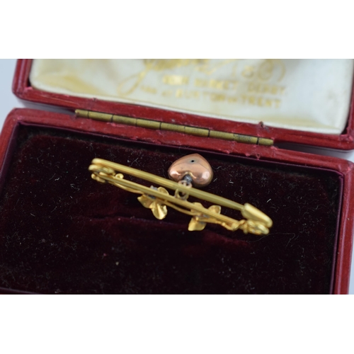 623 - 9ct gold brooch with suspended rose gold heart, floral design, 2.1g, in original case.