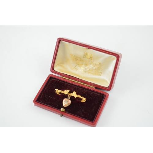 623 - 9ct gold brooch with suspended rose gold heart, floral design, 2.1g, in original case.