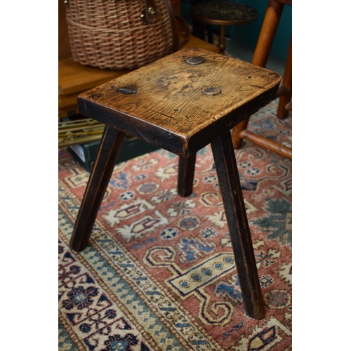 384 - Late 18th / early 19th century three legged country stool, made from elm / ash, showing signs of cha... 