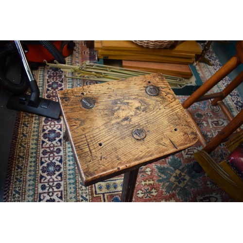 384 - Late 18th / early 19th century three legged country stool, made from elm / ash, showing signs of cha... 