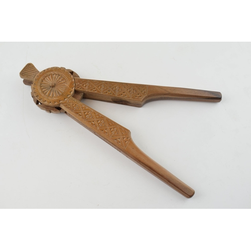 386 - 20th century treen nut cracker, carved decoration, 22cm long.