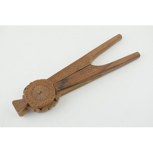 386 - 20th century treen nut cracker, carved decoration, 22cm long.