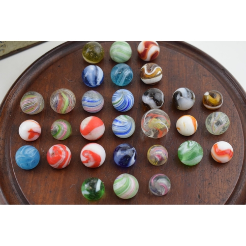 394 - A collection of antique and later marbles, swirling decoration, with vintage wooden games board (Qty... 