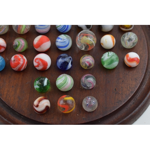 394 - A collection of antique and later marbles, swirling decoration, with vintage wooden games board (Qty... 