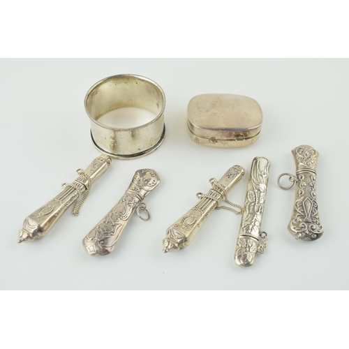 519 - Silver to include five ornate needle cases with a pill box and a napkin ring, combined 82.2g.