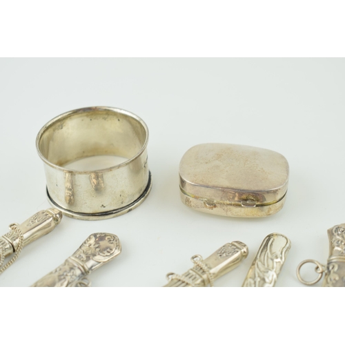 519 - Silver to include five ornate needle cases with a pill box and a napkin ring, combined 82.2g.