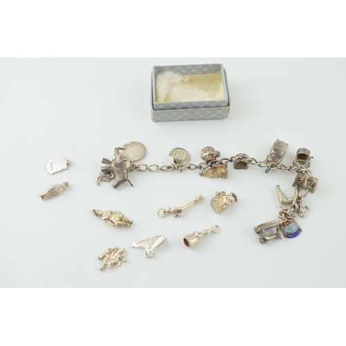 546 - A silver charm bracelet together with a quantity of loose charms. 56.9 grams.