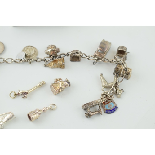 546 - A silver charm bracelet together with a quantity of loose charms. 56.9 grams.