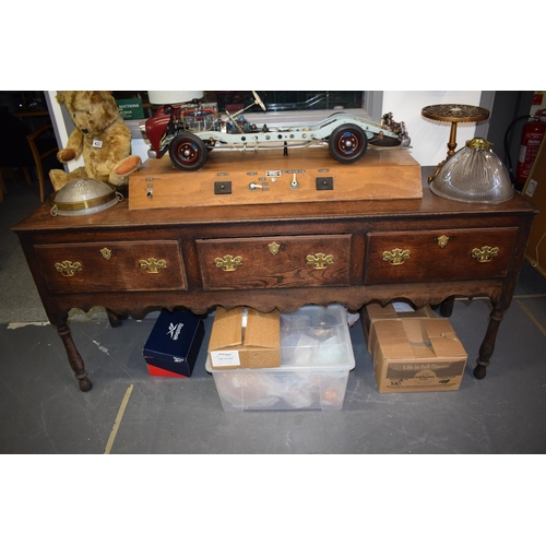 42 - Late 18th / early 19th century oak dresser base, three drawers, turned legs, brass handles and escut... 