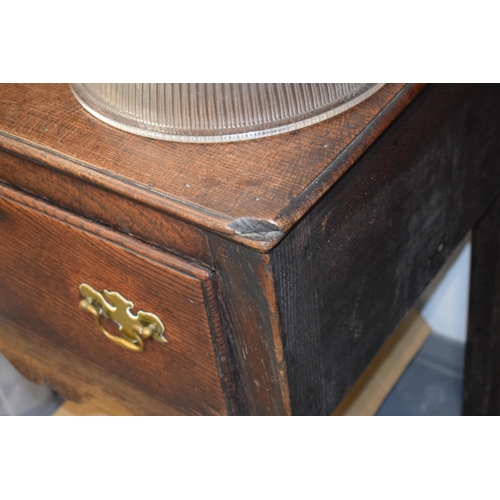 42 - Late 18th / early 19th century oak dresser base, three drawers, turned legs, brass handles and escut... 