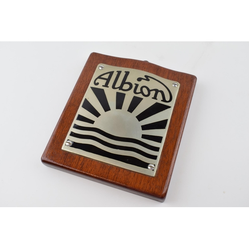 43 - An Albion Lorry badge mounted on mahogany plaque. 17cm x 15cm.