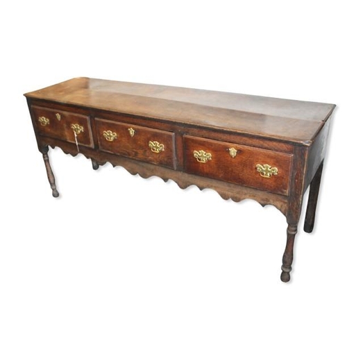 42 - Late 18th / early 19th century oak dresser base, three drawers, turned legs, brass handles and escut... 