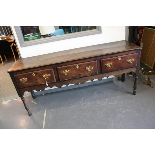 42 - Late 18th / early 19th century oak dresser base, three drawers, turned legs, brass handles and escut... 